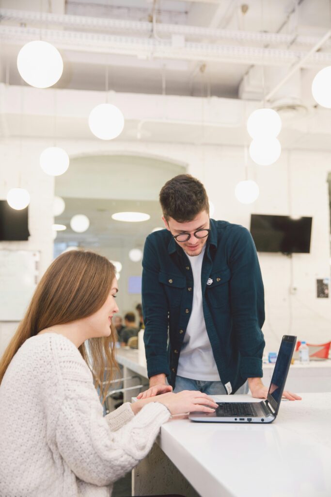 pexels-photo-3747140-3747140 Two young adults collaborating over a laptop in a modern, bright office setting.